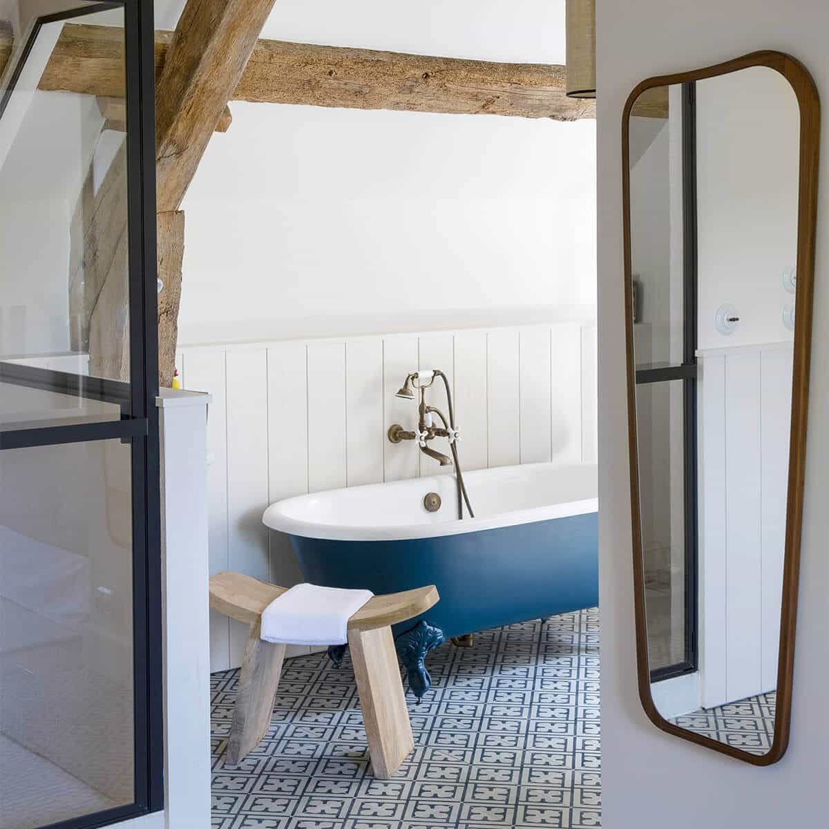 grand miroir accroché au bleu et blancmur dans une salle de bain