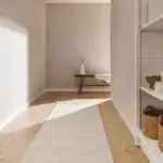 tapis couloir en laine beige avec pan de mur gris clair pour une déco épurée